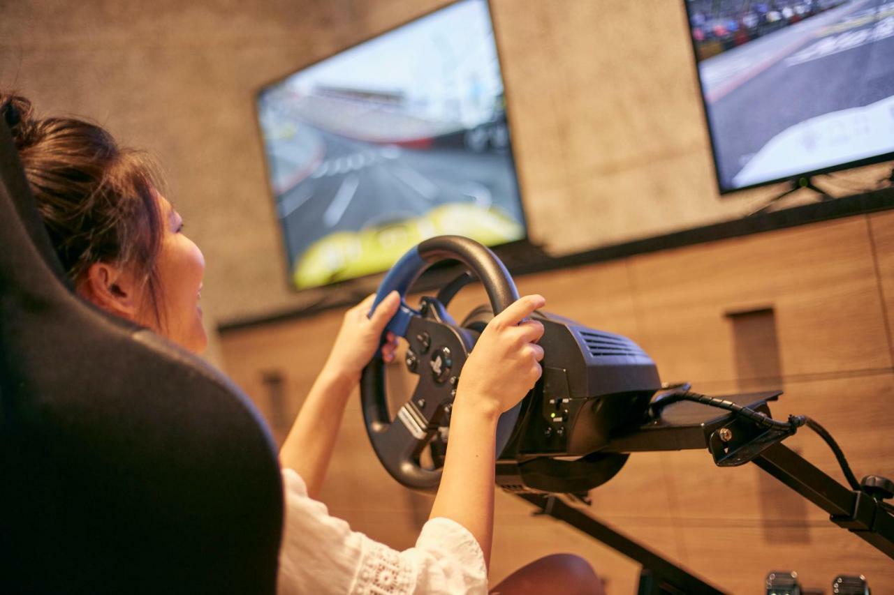 Mu 자오시 호텔 외부 사진 A woman playing a racing video game